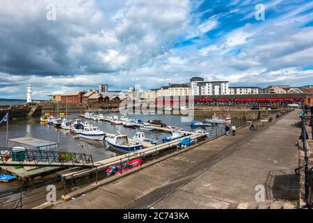 Newhaven Habour am westlichen Ende des Western Harbour Leith Docks Edinburgh Schottland mit Leuchtturm am Hafeneingang und Booten bei Ebbe festgemacht Stockfoto