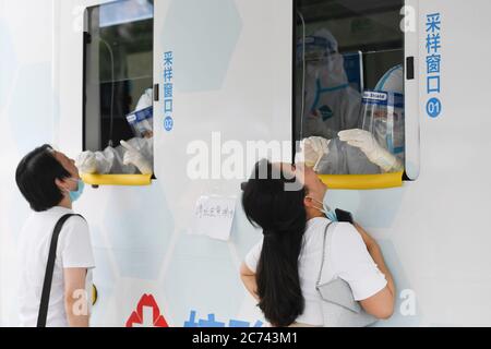 Peking, China. Juni 2020. Medizinisches Personal nimmt Rachenabstrichproben von Personen an einem neu eingefahrene mobile Testfahrzeug im Bezirk Xicheng in Peking, Hauptstadt von China, 28. Juni 2020. UM MIT XINHUA SCHLAGZEILEN VOM 14. JULI 2020 zu GEHEN Quelle: Ju Huanzong/Xinhua/Alamy Live News Stockfoto