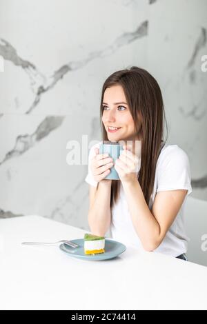 Eine Frau in ihrer Landesküche mit Kaffee und Kuchen Stockfoto