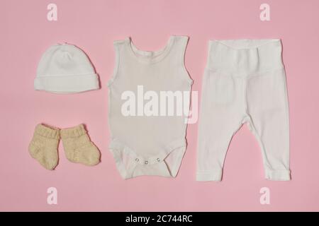 Baby Mode Konzept auf einem rosa Hintergrund. Mütze, Body, Hose und Socken. Stockfoto