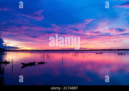 Wunderbare Landschaft in Lap an Lagune, Vietnam mit dem schwimmenden Haus, Holzboot und erstaunliche bunten Himmel des Sonnenaufgangs. Stockfoto