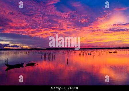 Wunderbare Landschaft in Lap an Lagune, Vietnam mit dem schwimmenden Haus, Holzboot und erstaunliche bunten Himmel des Sonnenaufgangs. Stockfoto