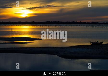 Wunderbare Landschaft in Lap an Lagune, Vietnam mit dem schwimmenden Haus, Holzboot und erstaunliche bunten Himmel des Sonnenaufgangs. Stockfoto