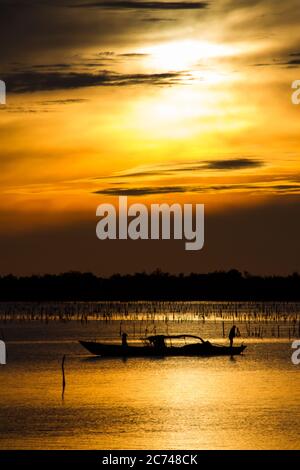 Wunderbare Landschaft in Lap an Lagune, Vietnam mit dem schwimmenden Haus, Holzboot und erstaunliche bunten Himmel des Sonnenaufgangs. Stockfoto