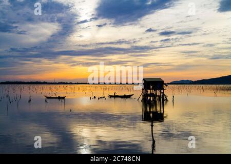 Wunderbare Landschaft in Lap an Lagune, Vietnam mit dem schwimmenden Haus, Holzboot und erstaunliche bunten Himmel des Sonnenaufgangs. Stockfoto