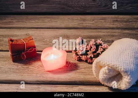 Spa Komposition mit herzförmiger Kerze und Spa Accessoires auf Holzhintergrund. Stockfoto