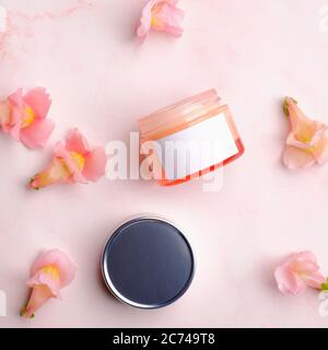 Geöffnete kosmetische Creme Glas Mockup auf rosa Hintergrund mit Blütenblättern. Hautpflege Schönheit Produkt Verpackung Design. Stockfoto