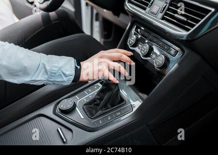 Geschäftsfrau hält ihre Hand auf dem Automatikgetriebe des Gangwahlschalters Stockfoto
