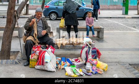 Teheran, Iran - Mai 2019: Iranischer Mann verkauft Sachen auf einer Bank im Stadtzentrum von Teheran Stockfoto