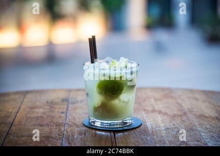 Auf dem Bild sieht man einen klassischen Rum-Cocktail auf einem Holztisch stehen und der Hintergrund des Bildes ist verschwommen Stockfoto