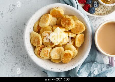 Pfannkuchen, Müsli, winzig dünne, lustige Krümel, Kinderessen. Frühstück mit Getränk Stockfoto