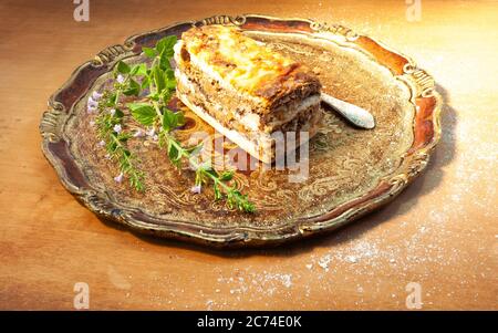 Typisch slowenisches Dessert mit cremigen Mohn-Samen, im Studio auf einem eleganten Holztablett Stockfoto