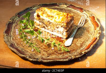 Typisch slowenisches Dessert mit cremigen Mohn-Samen, im Studio auf einem eleganten Holztablett Stockfoto