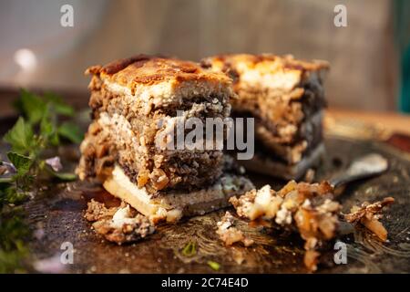 Typisch slowenisches Dessert mit cremigen Mohn-Samen, im Studio auf einem eleganten Holztablett Stockfoto