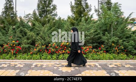 Qom, Iran - Mai 2019: Iranischer Mann, der eine Straße in Qom geht, die von schiitischen Muslimen als die zweitheiligste Stadt im Iran angesehen wird. Stockfoto