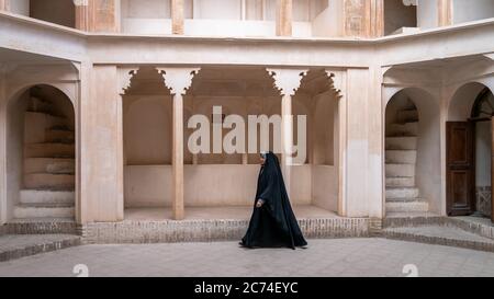 Kashan, Iran - Mai 2019: Iranische Frau in Chador Hijab beim Spaziergang im historischen Haus von Tabatabaei Natanzi Khaneh Stockfoto