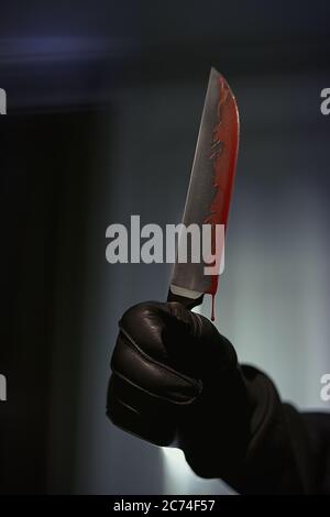 Ein Mann mit einem blutigen Messer in der Wohnung stehen, Hände Lederhandschuhe, bewaffnete Raub, rücksichtslosen Attentäter Stockfoto