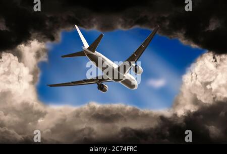 Flugzeug bricht durch dunkle Wolken in einen blauen Himmel Stockfoto