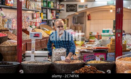 Isfahan, Iran - Mai 2019: Iraner verkauft Snacks in seinem Geschäft im Großen Basar von Isfahan Stockfoto