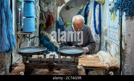 Isfahan, Iran - Mai 2019: Iraner verkauft in seinem Geschäft im Großen Basar von Isfahan Saiten und Seile Stockfoto