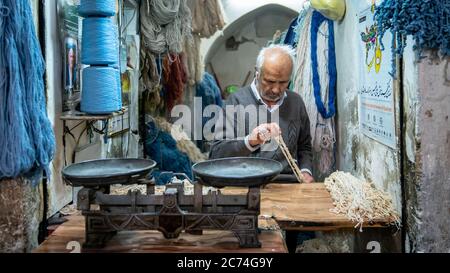 Isfahan, Iran - Mai 2019: Iraner verkauft in seinem Geschäft im Großen Basar von Isfahan Saiten und Seile Stockfoto