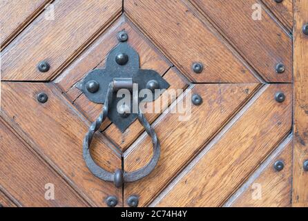 Türgriff aus geschmiedetem Metall mit einem Ring an einer Holztür. Stockfoto