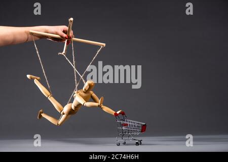 Beschnittene Ansicht des Puppenspielers mit Holzmarionette mit Warenkorb auf schwarz Stockfoto