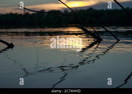 Sommeruntergang am Ufer eines großen Flusses Stockfoto