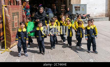 Isfahan, Iran - Mai 2019: Schulkinder mit ihren Lehrern gehen auf einer Straße Stockfoto