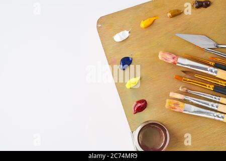 Palette mit Farben und Pinsel für Ölmalerei auf weißem Hintergrund Stockfoto
