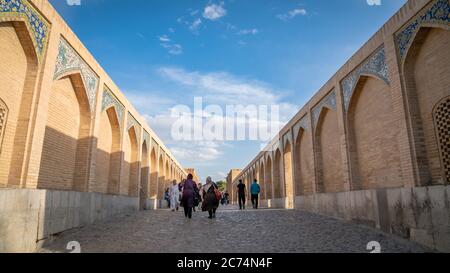 Isfahan, Iran - Mai 2019: Khaju Brücke über Zayandeh Fluss mit Touristen und Einheimischen herumlaufen Stockfoto