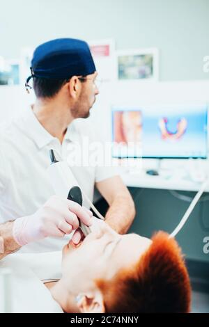 Zahnarzt Arzt während der Arbeit in einem Stuhl mit einem Patienten - Behandlung und Prothetik Stockfoto