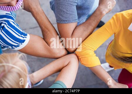 Junge Leute Freunde stoßen ihre Ellbogen, anstatt mit einer Umarmung zu grüßen - vermeiden Sie die Ausbreitung von Coronavirus, soziale Distanz und Freundschaftskonzept Stockfoto