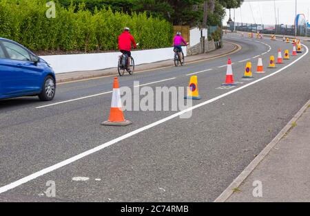 Sandbanks, Poole, Dorset, Großbritannien. Juli 2020. Der Evening Hill in Sandbanks ist ein beliebter Ort für Leute, die die spektakuläre Aussicht und Sonnenuntergänge über dem Hafen von Poole bewundern und fotografieren möchten. Es ist die Hauptverbindung von/nach Sandbanks, wo es in geschäftigen Zeiten zu voll wird. 43 Parkplätze auf der Straße werden entfernt und durch einen Probefahrradweg mit 240 Meter flexiblen Pollern ersetzt, um die Menschen zur Unterstützung der Klima- und ökologischen Ambitionen des Rates und im Rahmen von Maßnahmen für die Abteilung für Transport Emergency Active Travel Fund zu ermutigen, mit dem Fahrrad zu fahren. Quelle: Carolyn Jenkins/Alamy Live News Stockfoto