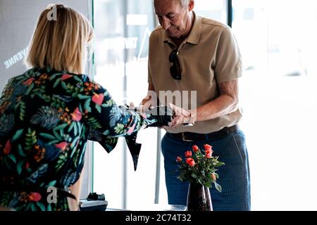 Take-away-Service an der Restauranttür - Arbeiter, der dem Kunden verpackte Speisen gibt Stockfoto