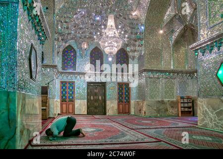 Shiraz, Iran - Mai 2019: Nicht identifizierter Mann, der im Schah e Cheragh-Schrein und Mausoleum, der Spiegelmoschee, betet Stockfoto