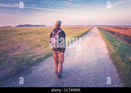 Der Mann mit dem Rucksack geht den Weg, Herbstblick Stockfoto
