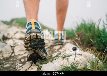 Nahaufnahme des Bildes Reisende Füße in Wanderstiefeln auf Bergfelspfad im Sommer. Stockfoto