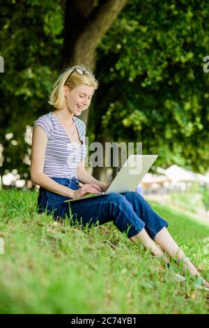 Im Freien zu sein, setzt die Arbeiter frischer Luft und Umweltveränderungen aus, die glücklich und gesund auf körperlicher und emotionaler Ebene machen. Mädchen Laptop im Freien. Warum Mitarbeiter im Freien arbeiten müssen. Stockfoto