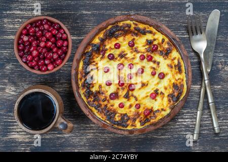 Süße Quark Auflauf mit Rosinen und Grieß auf hölzernen Tisch. Keramische Schüssel mit gebackenen Cottage Käse Auflauf, Nahaufnahme, Ansicht von oben Stockfoto