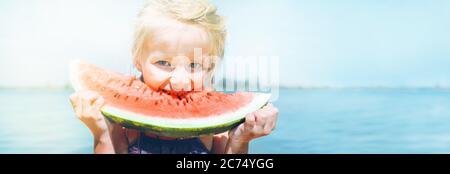 Kleines Mädchen in rosa Sonnenbrille mit großen Wassermelone Segment lustige Porträt. Gesunde Ernährung Konzept Bild. Stockfoto