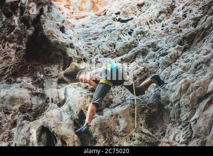 Junge Bergsteiger klettern auf Kletterroute mit Seil am Tonsay Strand in Krabi, Thailand. Stockfoto
