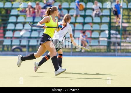 Junge Frauen spielen Hockey-Spiel auf dem Spielfeld. Weibliche Hockey Spiel Bild Stockfoto