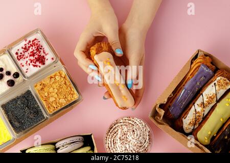 Weibliche Hände halten Dessert in den Händen zwischen frischen Süßwaren Stockfoto