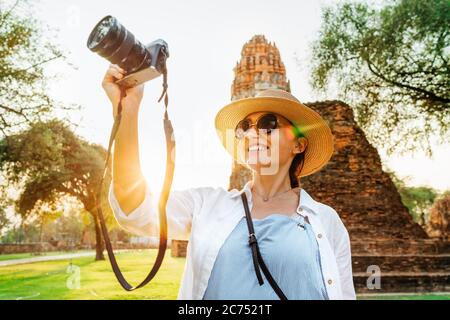 Tourist Frau fotografieren alte Ruinen mit Kompaktkamera zu Fuß durch die Straßen der alten Ayutthaya Stadt, Thailand Stockfoto