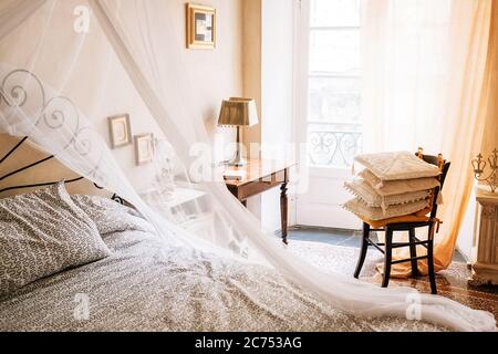 Vintage Möbel Retro sonnige Wohnung mit Baldachin Bett, Stuhl, gemütliche Kissen, Lampe, gerahmte Bilder an den Wänden Stockfoto