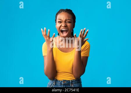 Emotional Girl Screaming Hände Halten In Der Nähe Gesicht Über Blauen Hintergrund Stockfoto