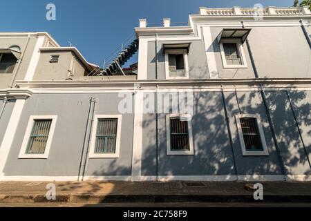 Pondicherry. Indien - Februar 2020: Ein altes französisches Gebäude mit rechteckigen Fenstern und grauen Wänden in der Stadt Pondicherry. Stockfoto