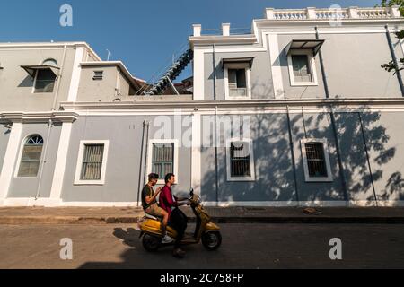 Pondicherry. Indien - Februar 2020: Alte exquisite französische Architektur mit malerischen, rechteckigen Fenstern und grauen Wänden auf den Straßen von Pondicherry. Stockfoto