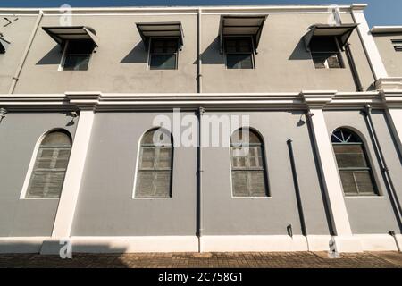 Pondicherry, Indien - Februar 2020: Die alten grauen Wände mit gewölbten Fenstern eines alten französischen Gebäudes in der Stadt Pondicherry. Stockfoto